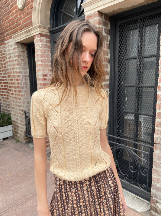 girl wearing cream sweater and brown skirt