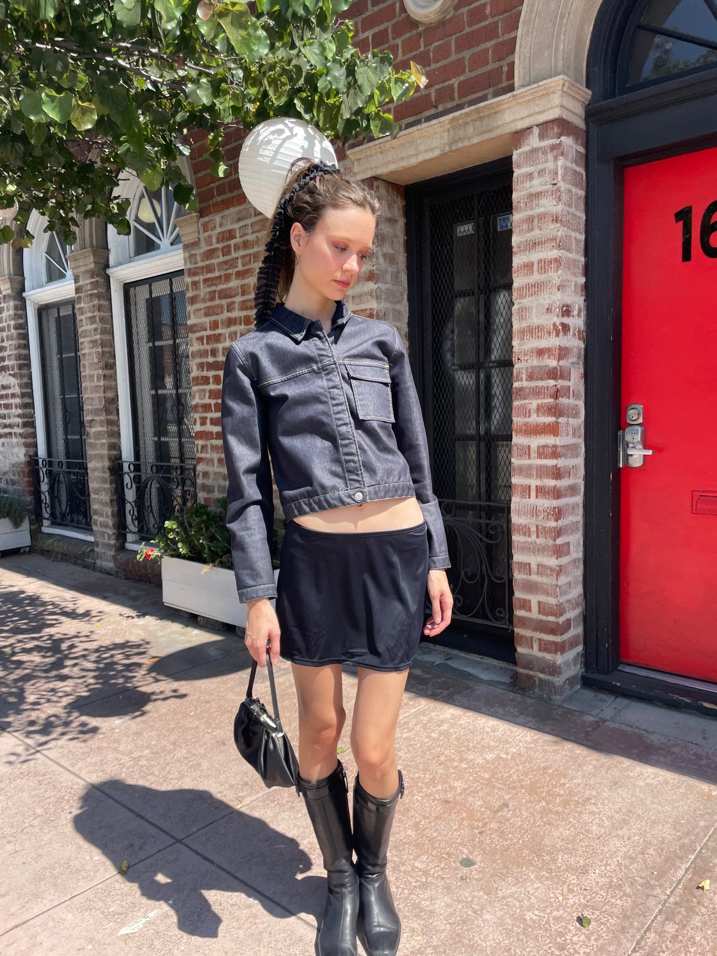 girl in denim jacket, black skirt and leather boots