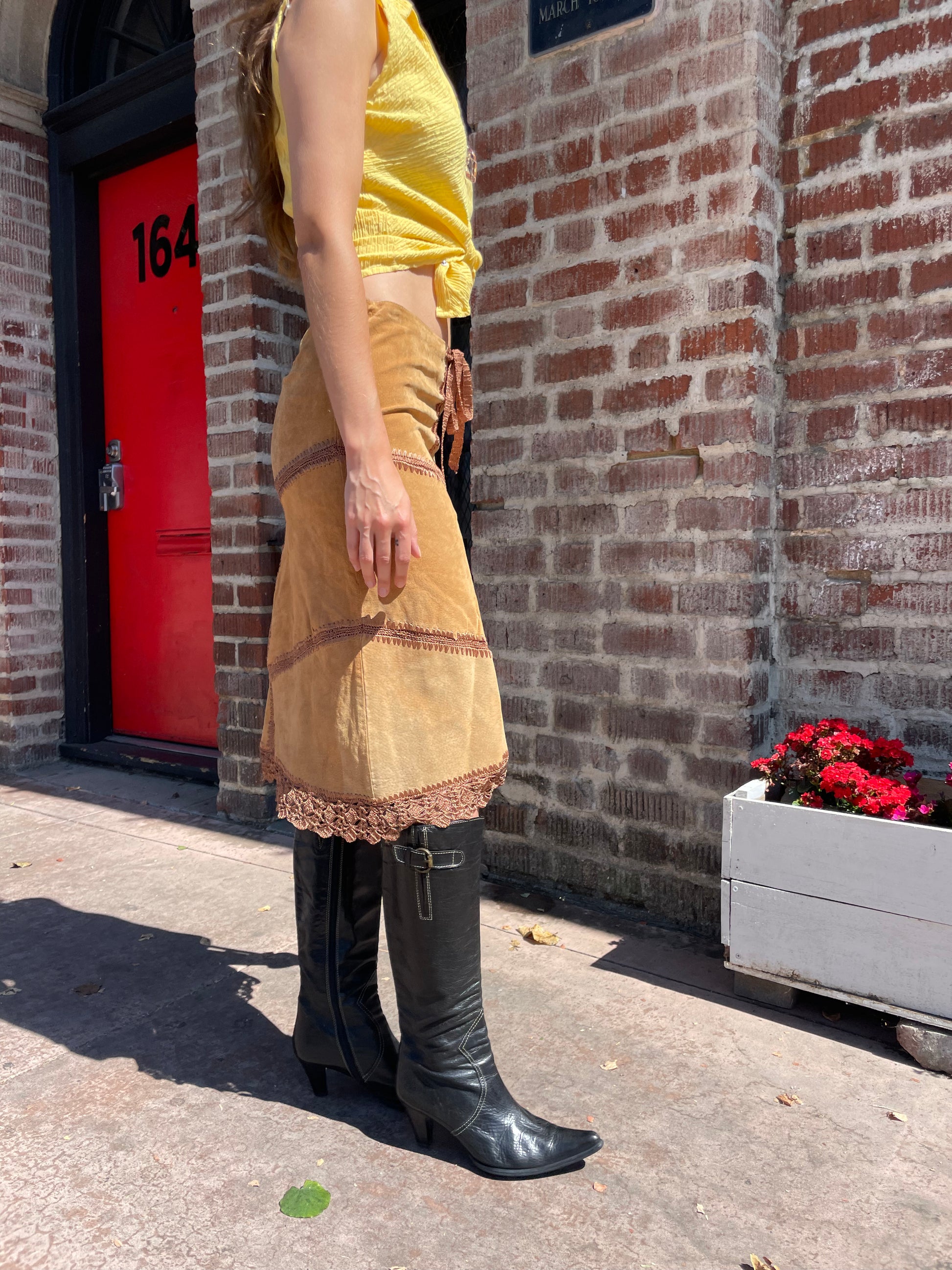 girl wearing tan leather skirt and yellow top