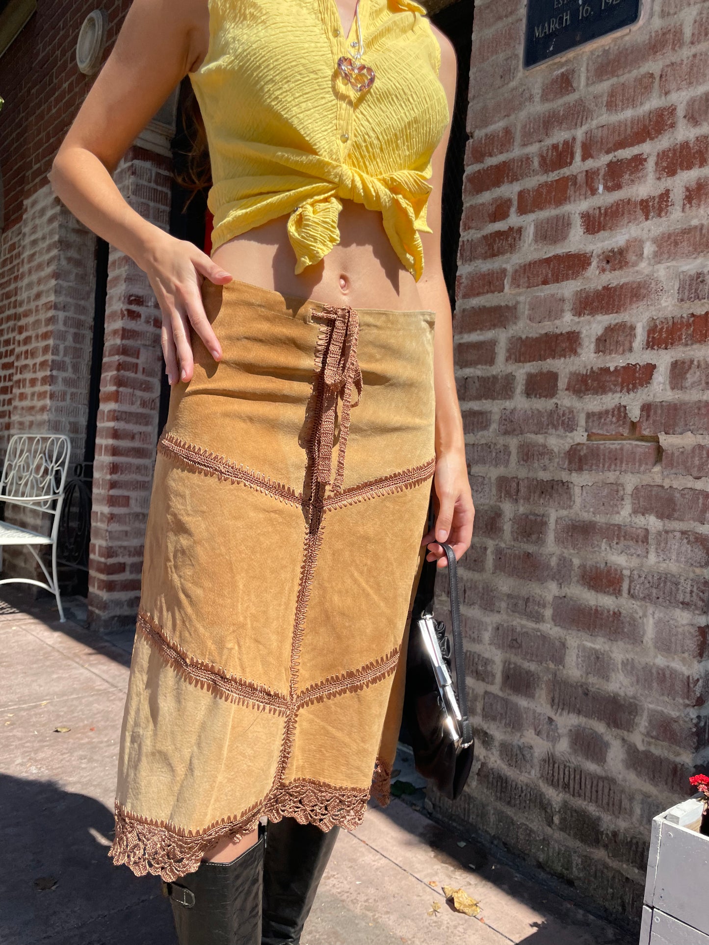 girl wearing tan leather skirt and yellow top