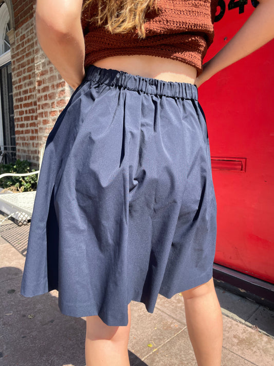 girl in navy skirt and orange top