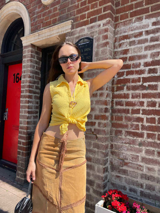 girl in tan leather skirt and yellow top