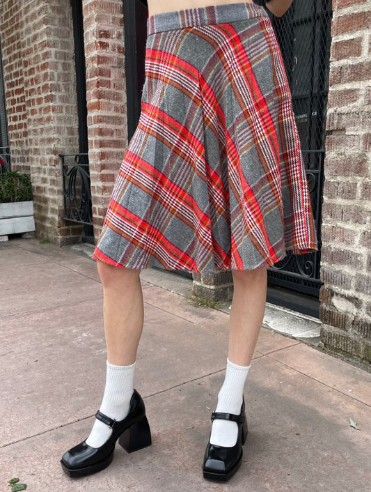 girl wearing graphic t-shirt and plaid skirt