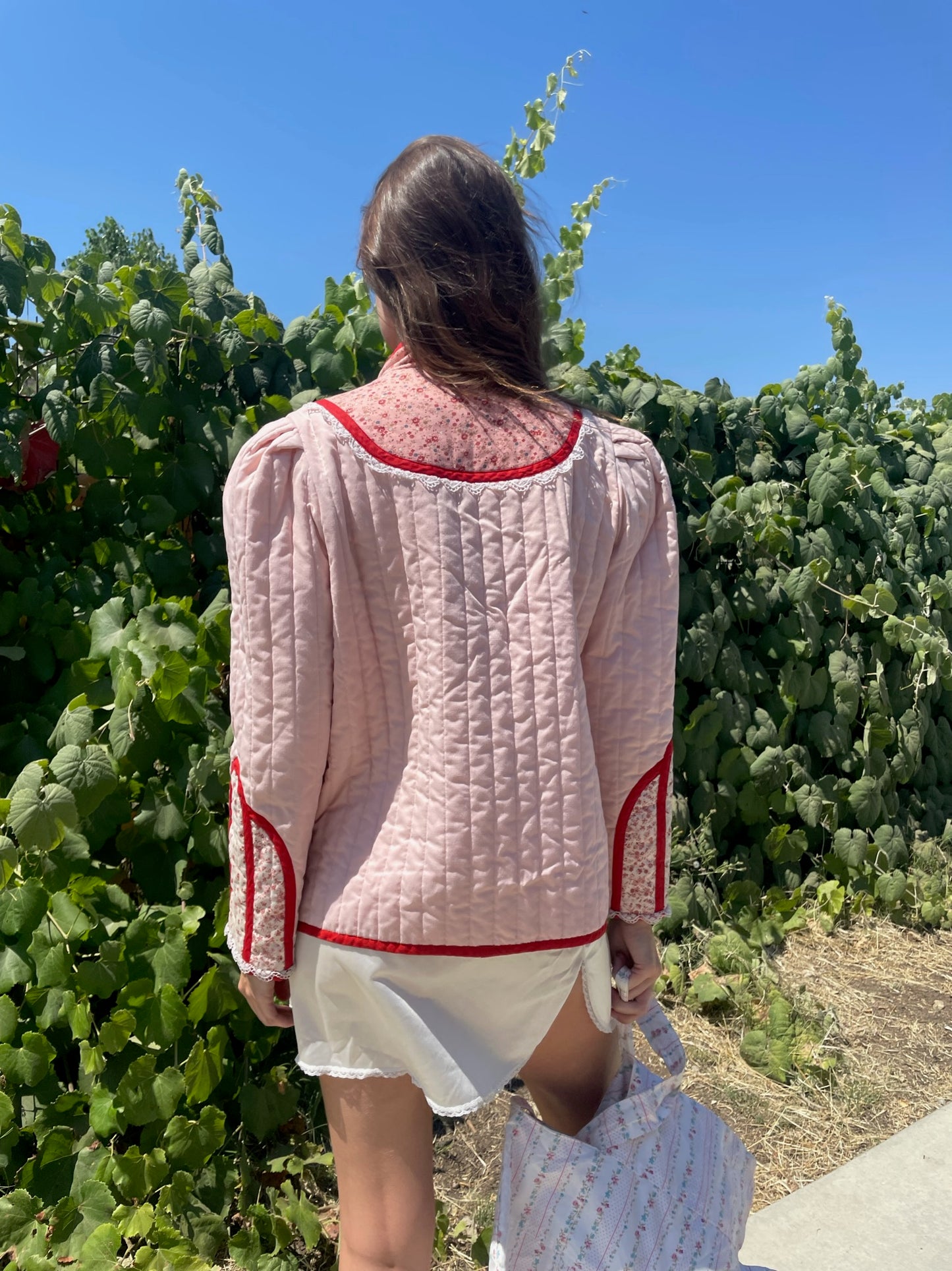 girl in pink jacket and white skirt