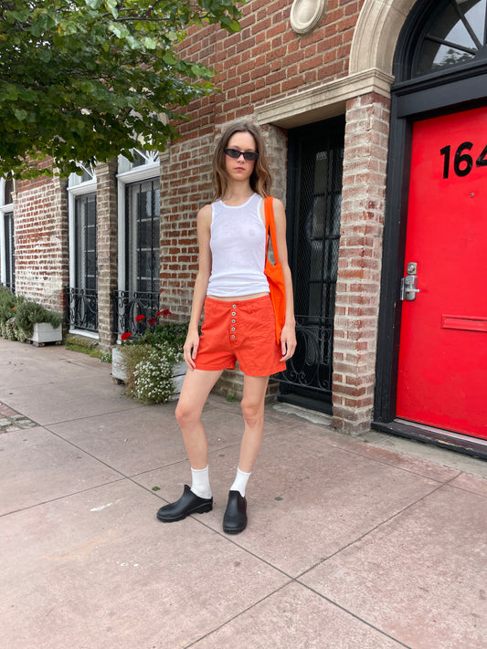 girl in white tank and orange shorts