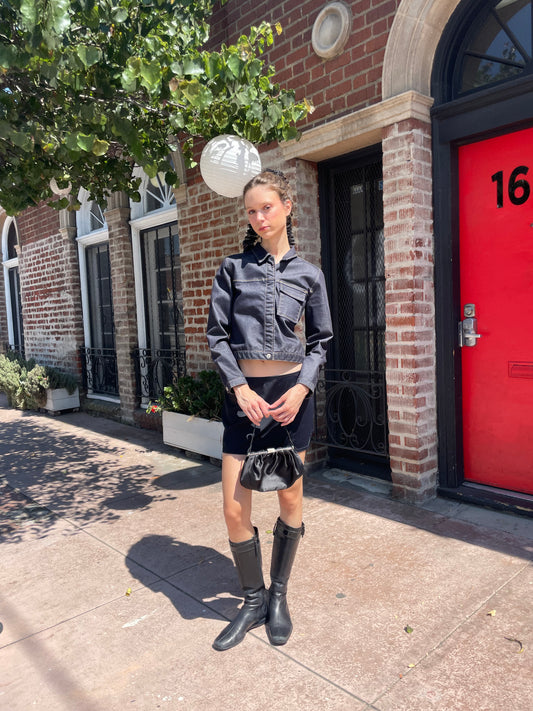 girl in denim jacket, black skirt and leather boots