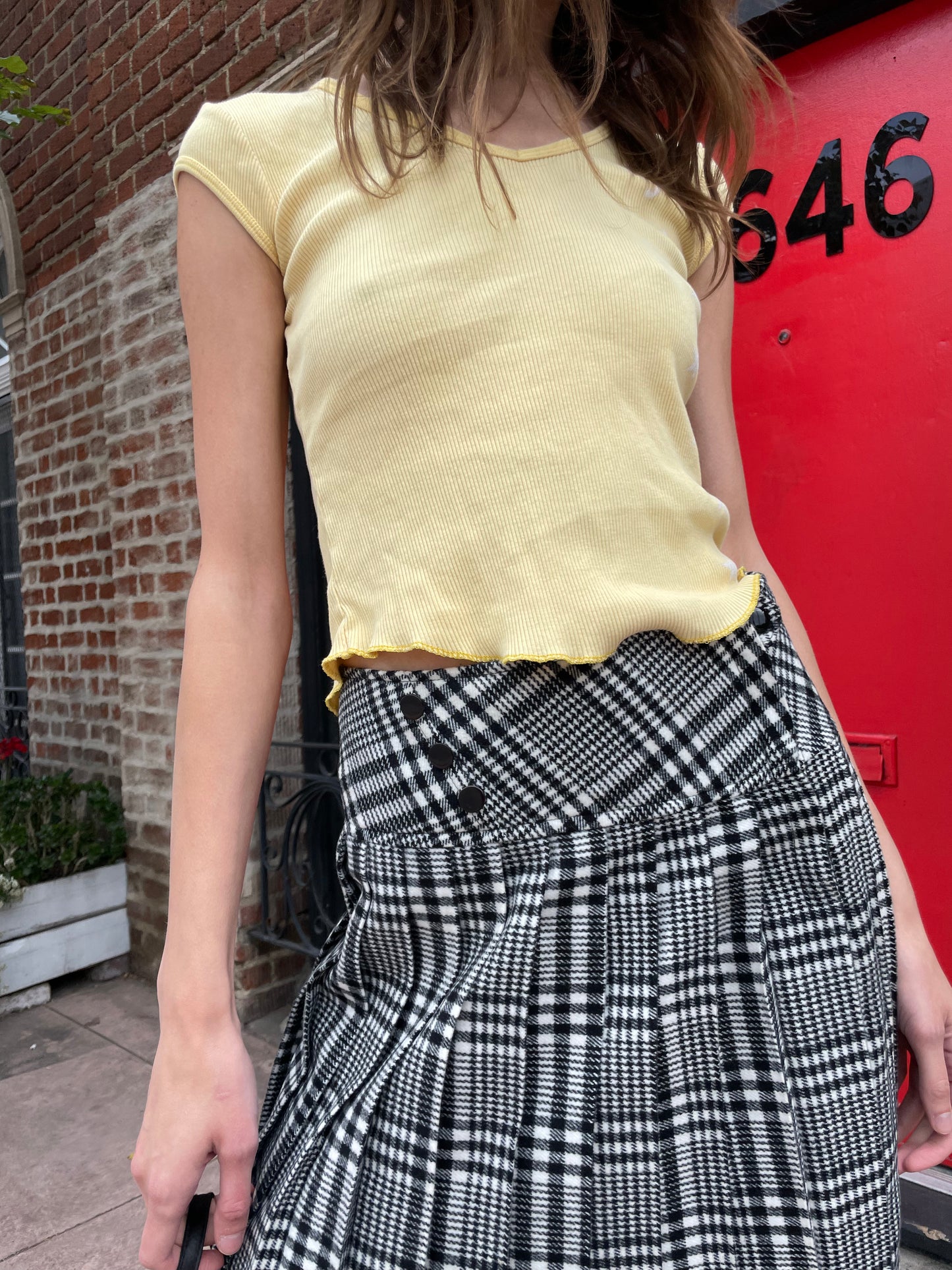 girl in yellow top and black and white skirt