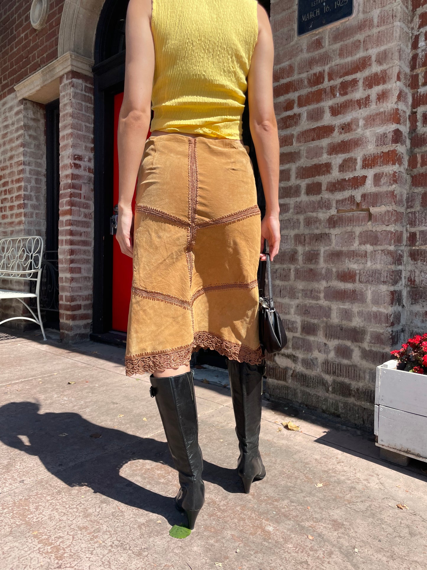 girl wearing tan leather skirt and yellow top