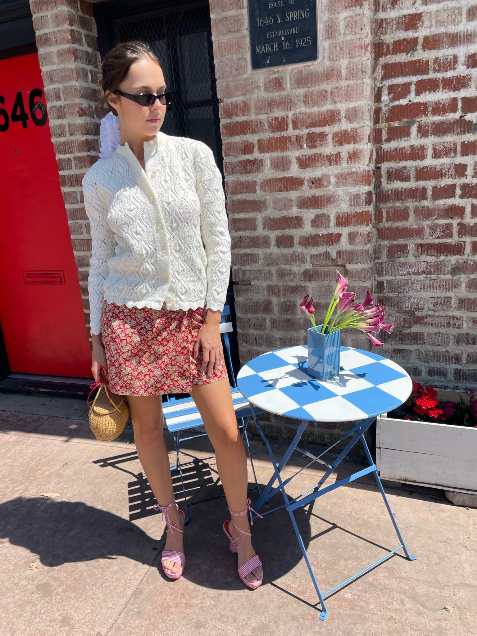 girl wearing red floral skirt and white cardigan