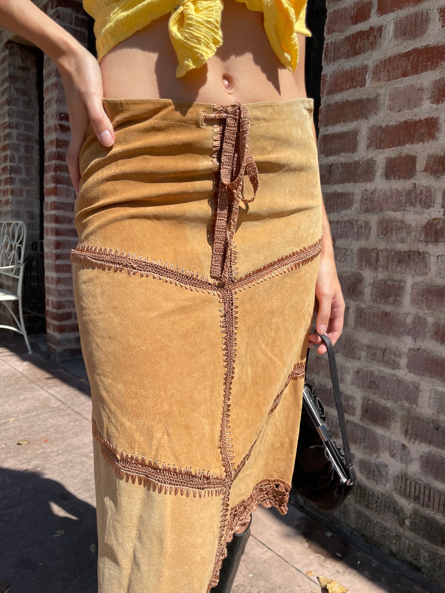 girl wearing tan leather skirt and yellow top