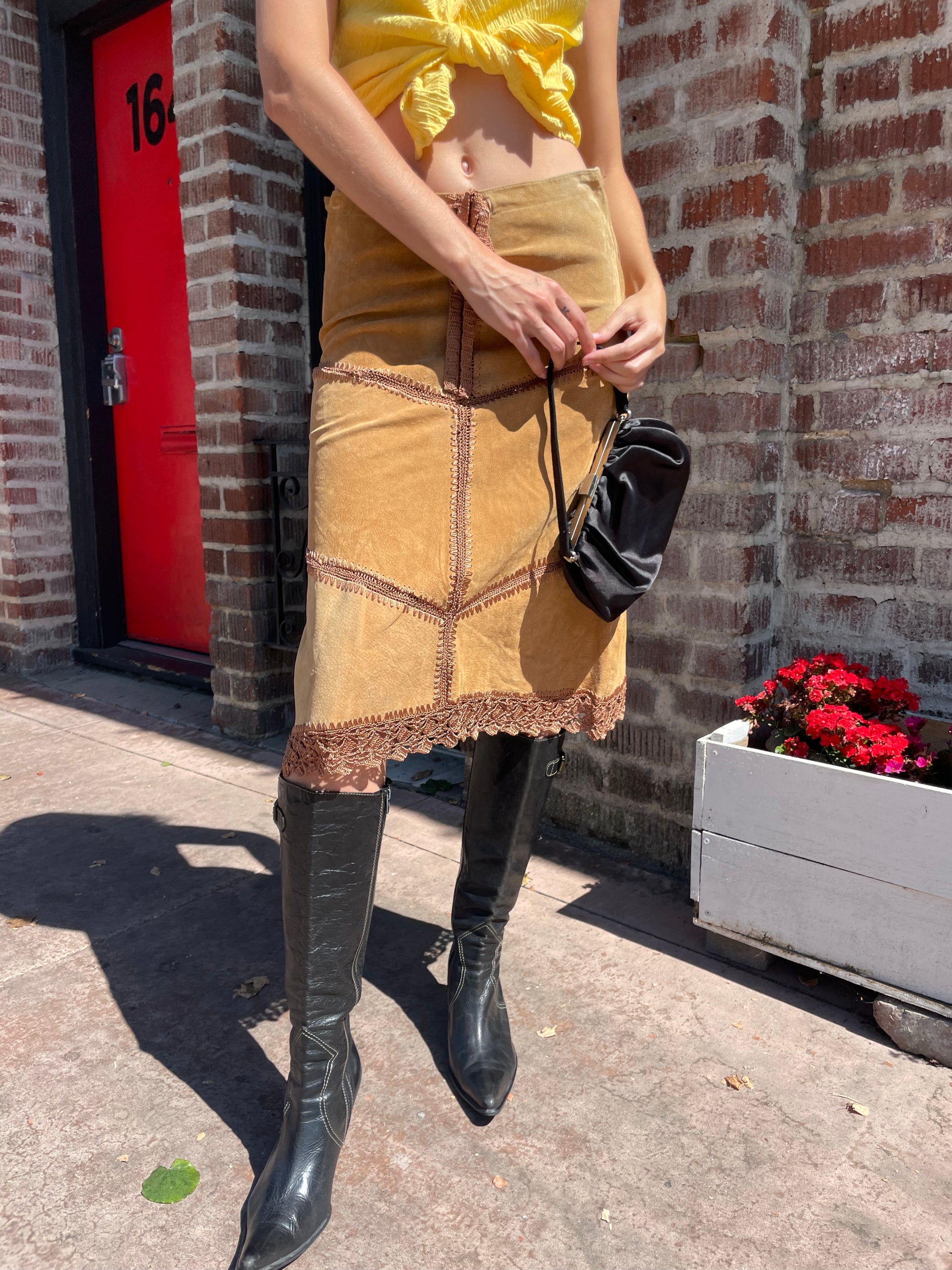 girl wearing tan leather skirt and yellow top