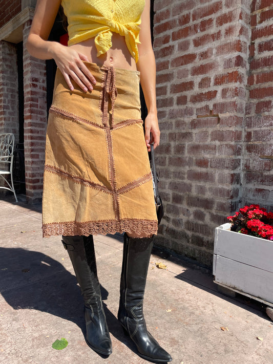 girl wearing tan leather skirt and yellow top