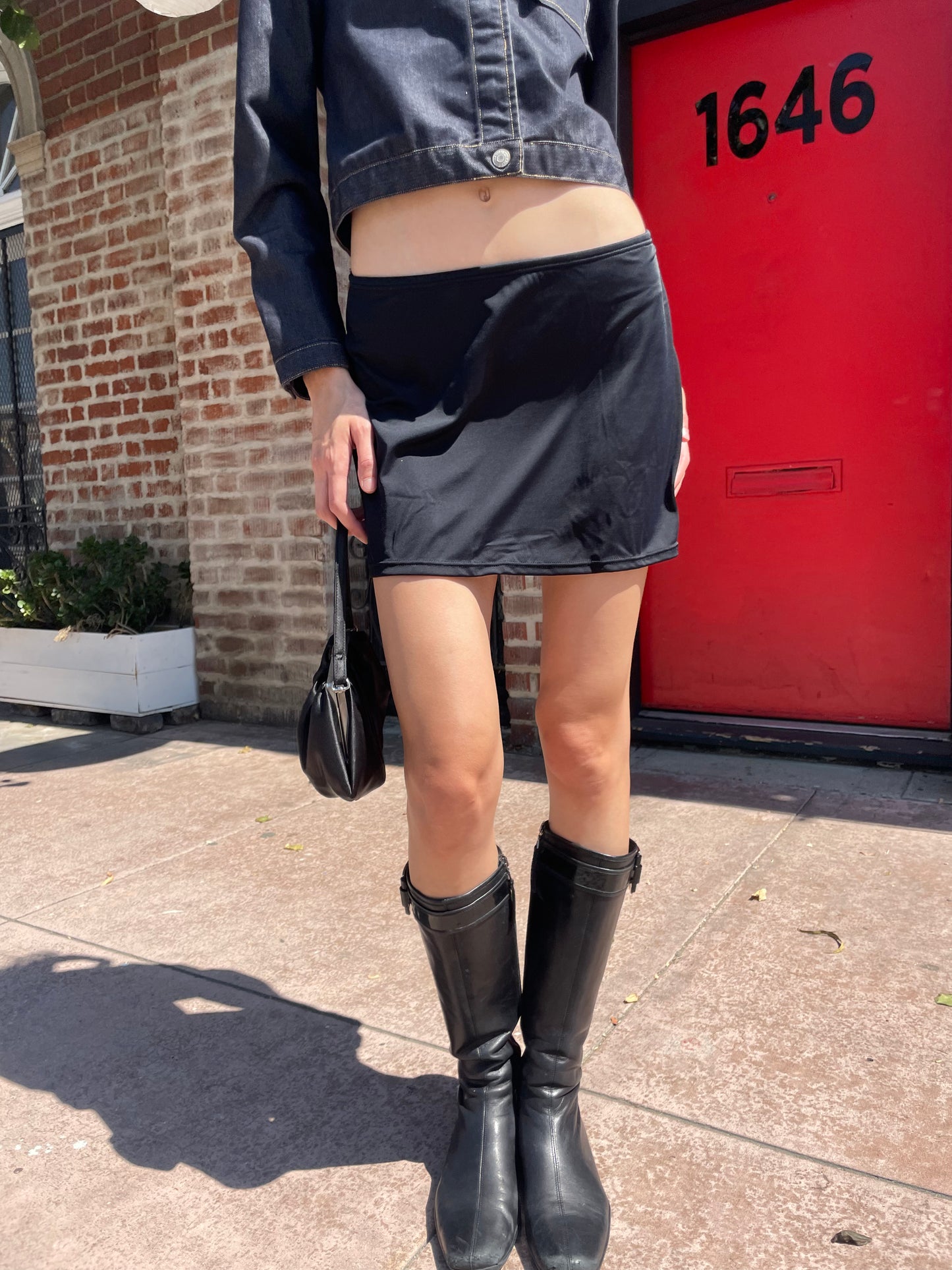 girl in denim jacket, black skirt and leather boots