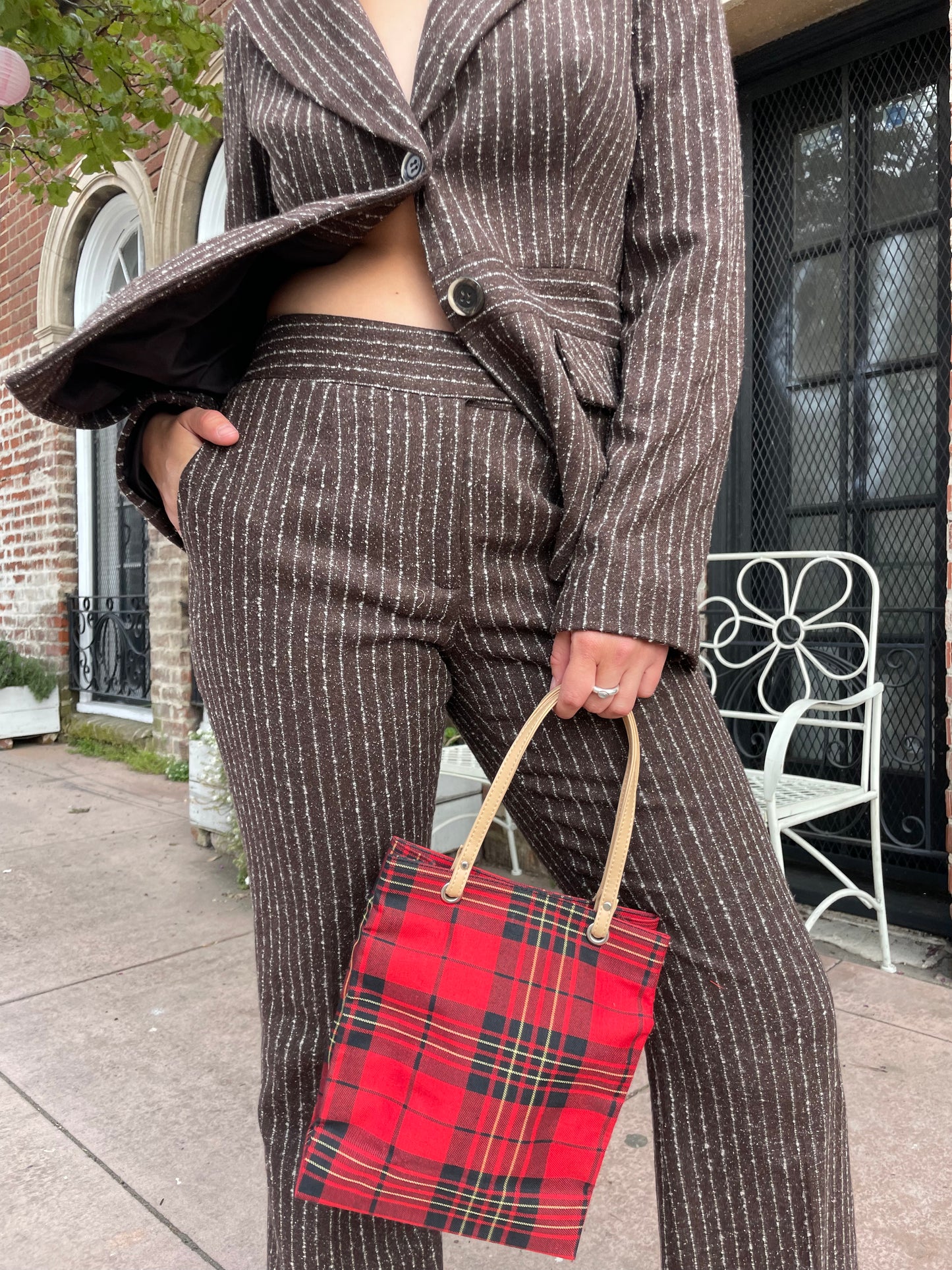 girl wearing brown blazer and slacks set with red plaid purse