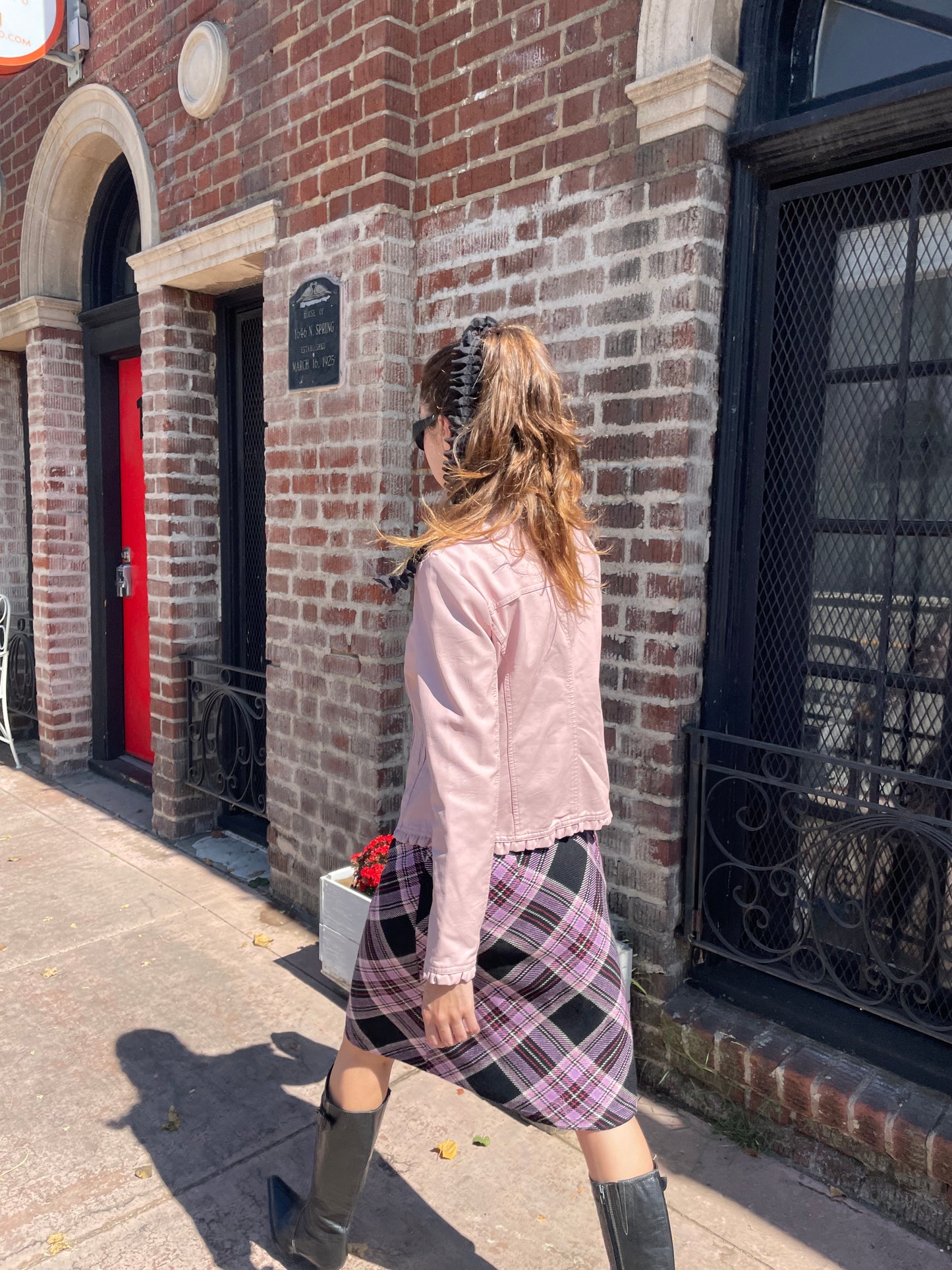 girl in plaid skirt and pink jacket