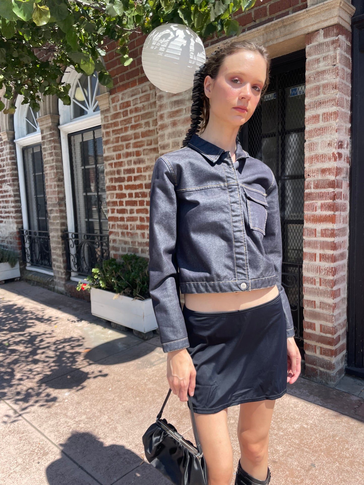 girl in denim jacket, black skirt and leather boots