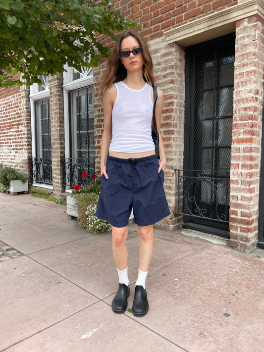 girl wearing white tank top and blue shorts