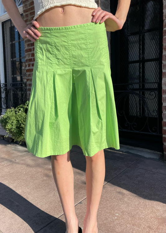 girl wearing a tan top and green skirt