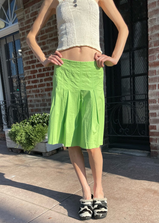 girl wearing a tan top and green skirt
