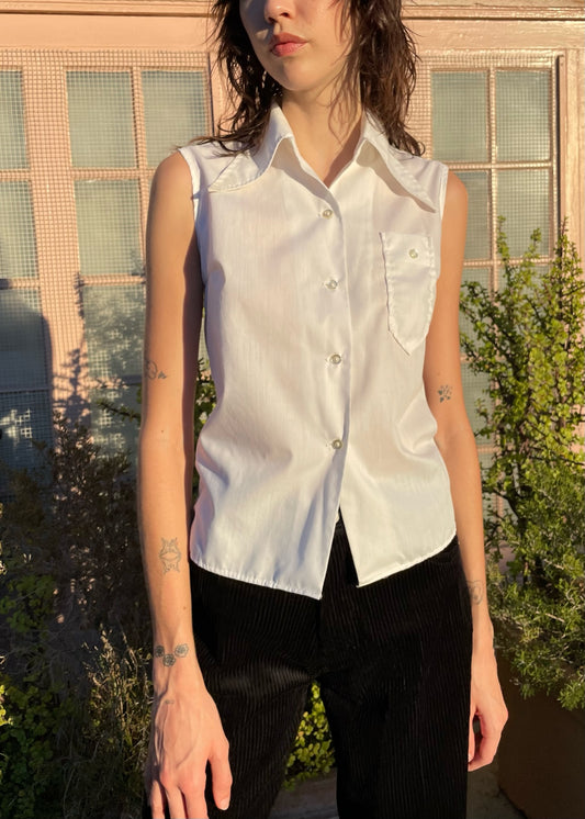 girl wearing sleaveless white button up and black pants