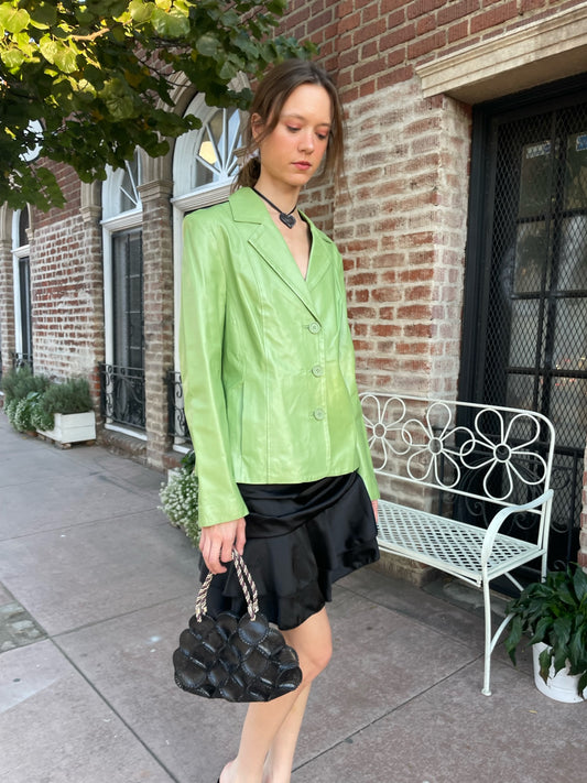 girl wearing shiny green blazer and black skirt
