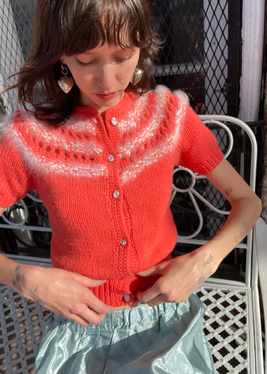 girl wearing red knit top and silvery skirt