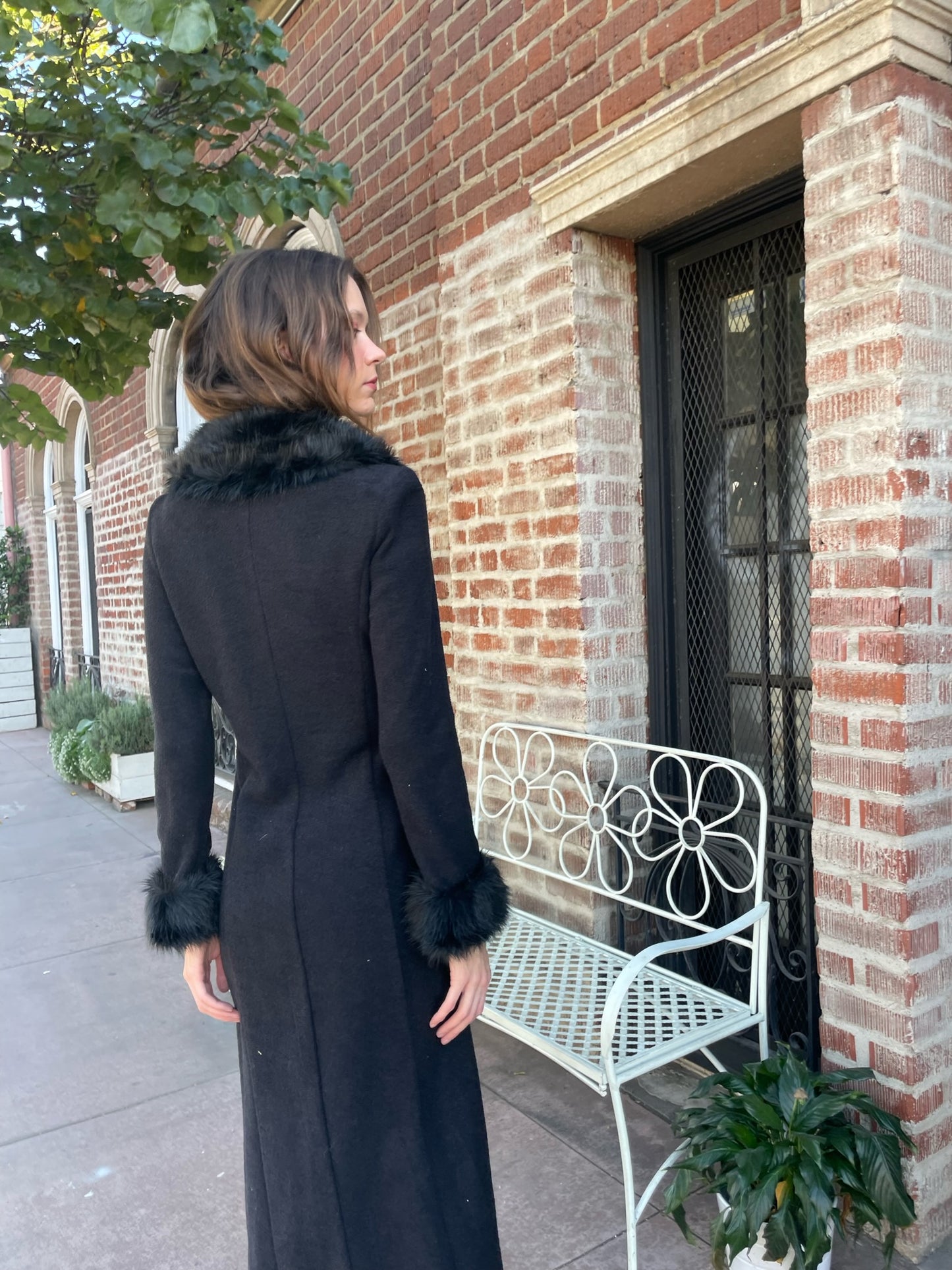 back of girl girl wearing a black fur collar coat