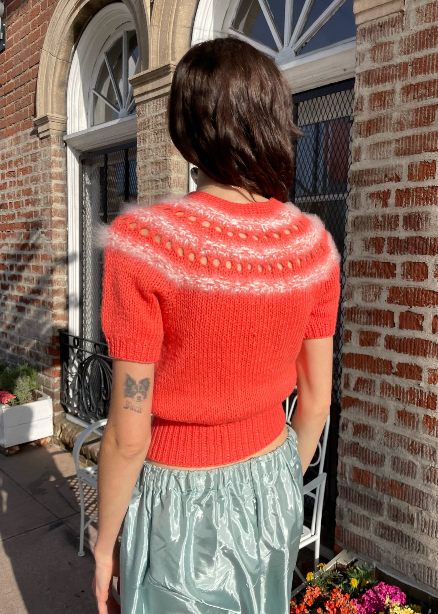 girl wearing red knit top and silvery skirt