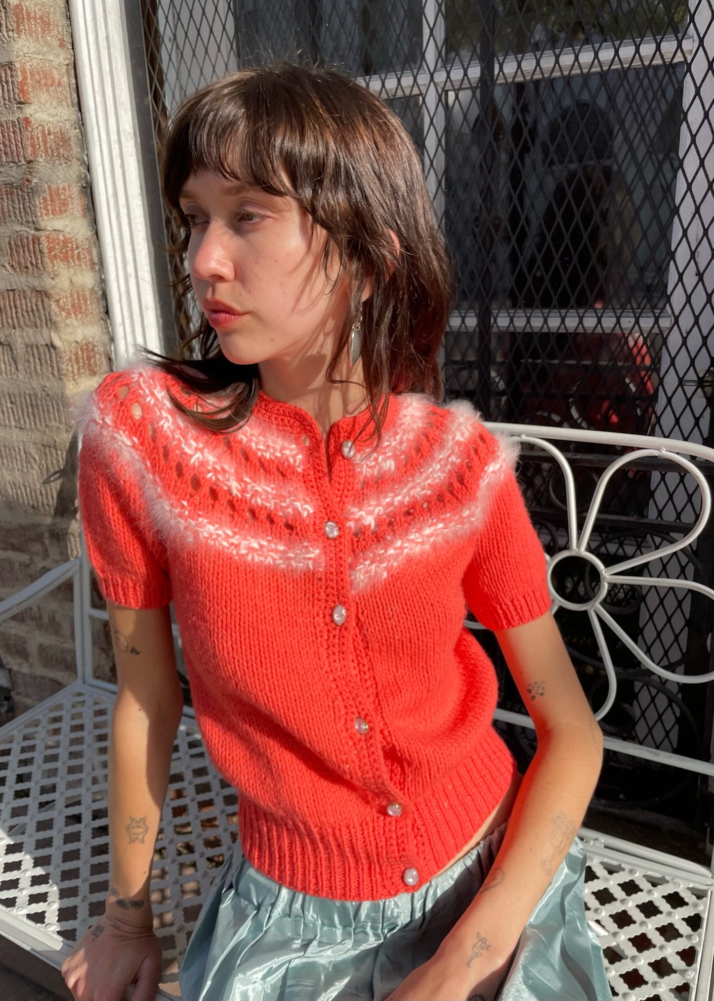 girl wearing red knit top and silvery skirt