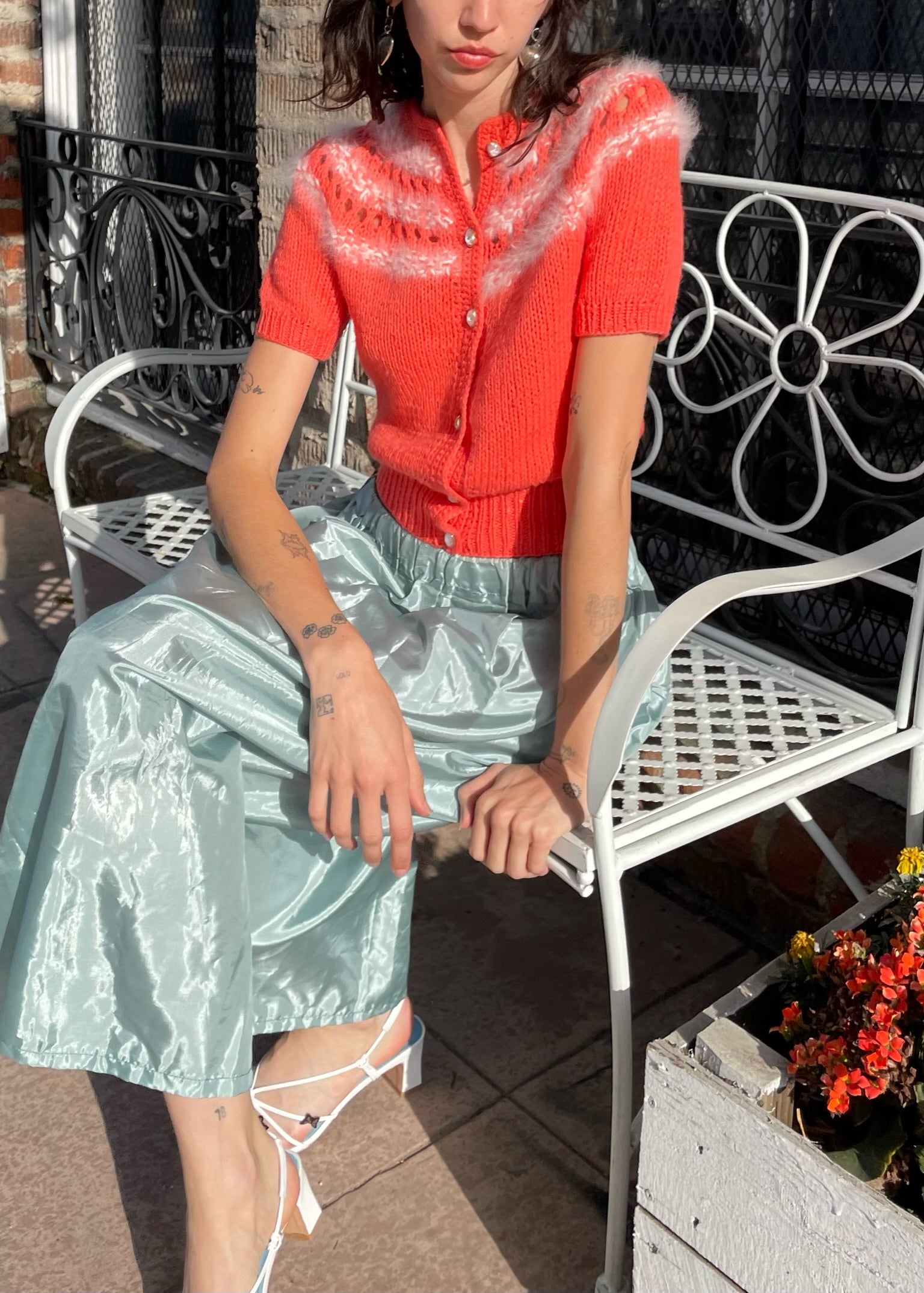 girl wearing red knit top and silvery skirt