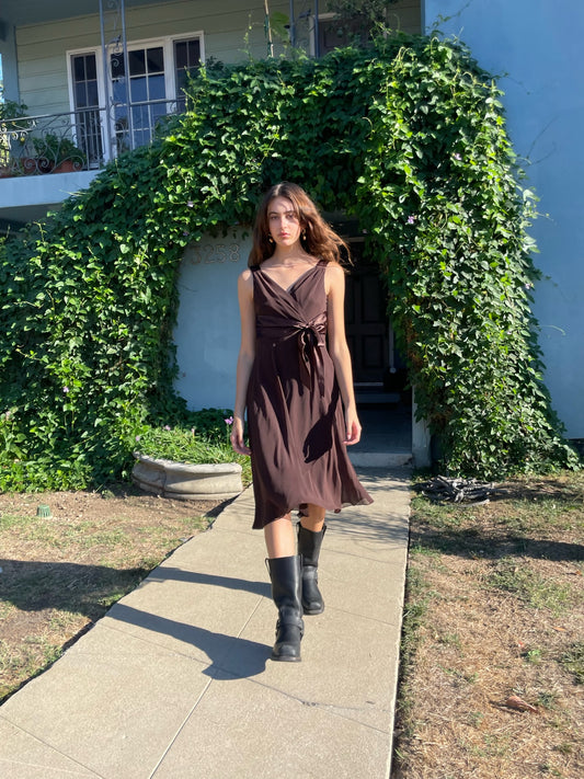 girl walking down the sidewalk wearing a brown dress and black boots