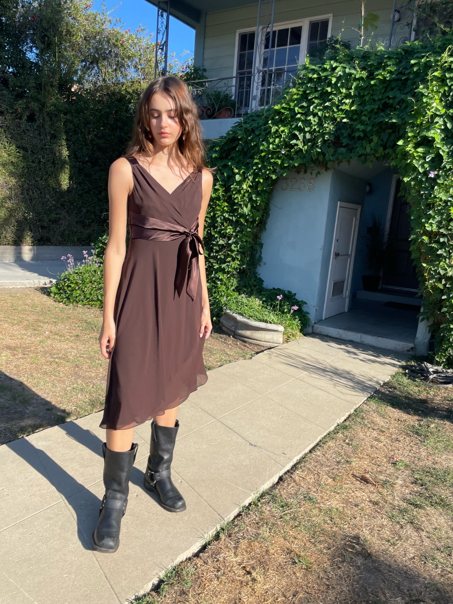 girl standing wearing a brown dress