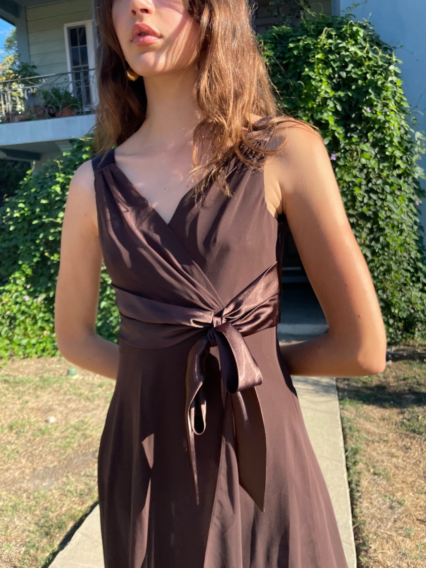 close up of sash on a brown dress that a girl is wearing