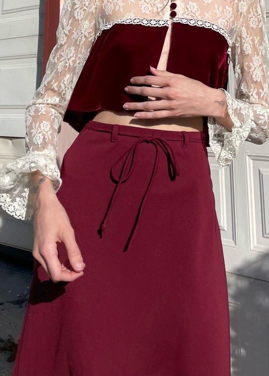 girl wearing red and white lace top and long red skirt