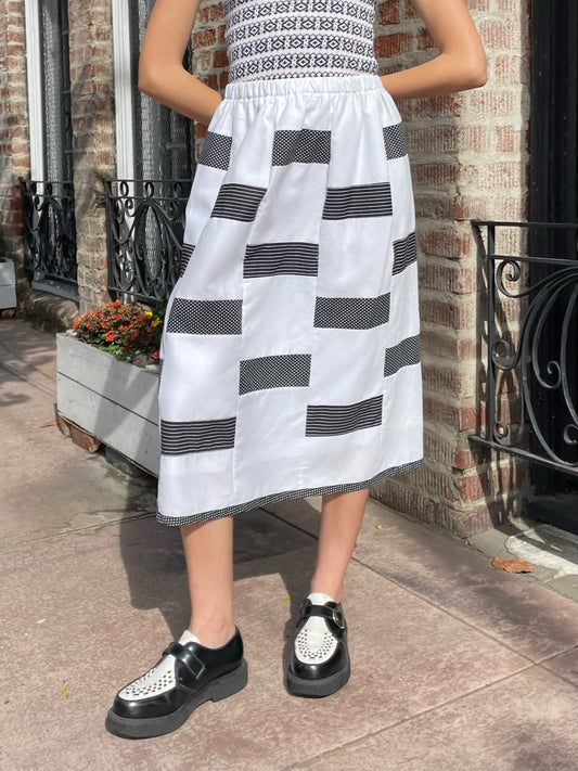 lower half of girl wearing black and white skirt