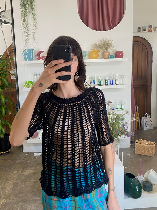 girl  wearing black crochet top and blue flare pants