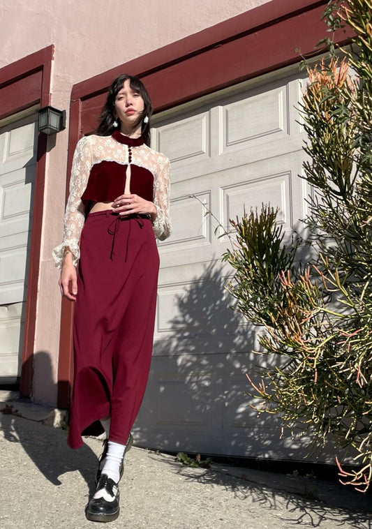 girl wearing red and white lace top and long red skirt